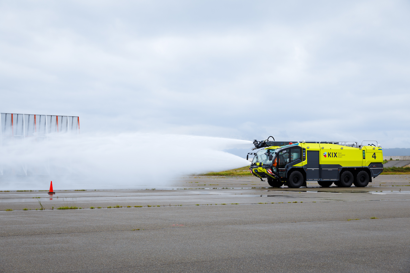 空港用化学消防車から水と消火薬剤を噴射している写真／Photo of an airport chemical fire engine spraying water and a fire extinguishing agent