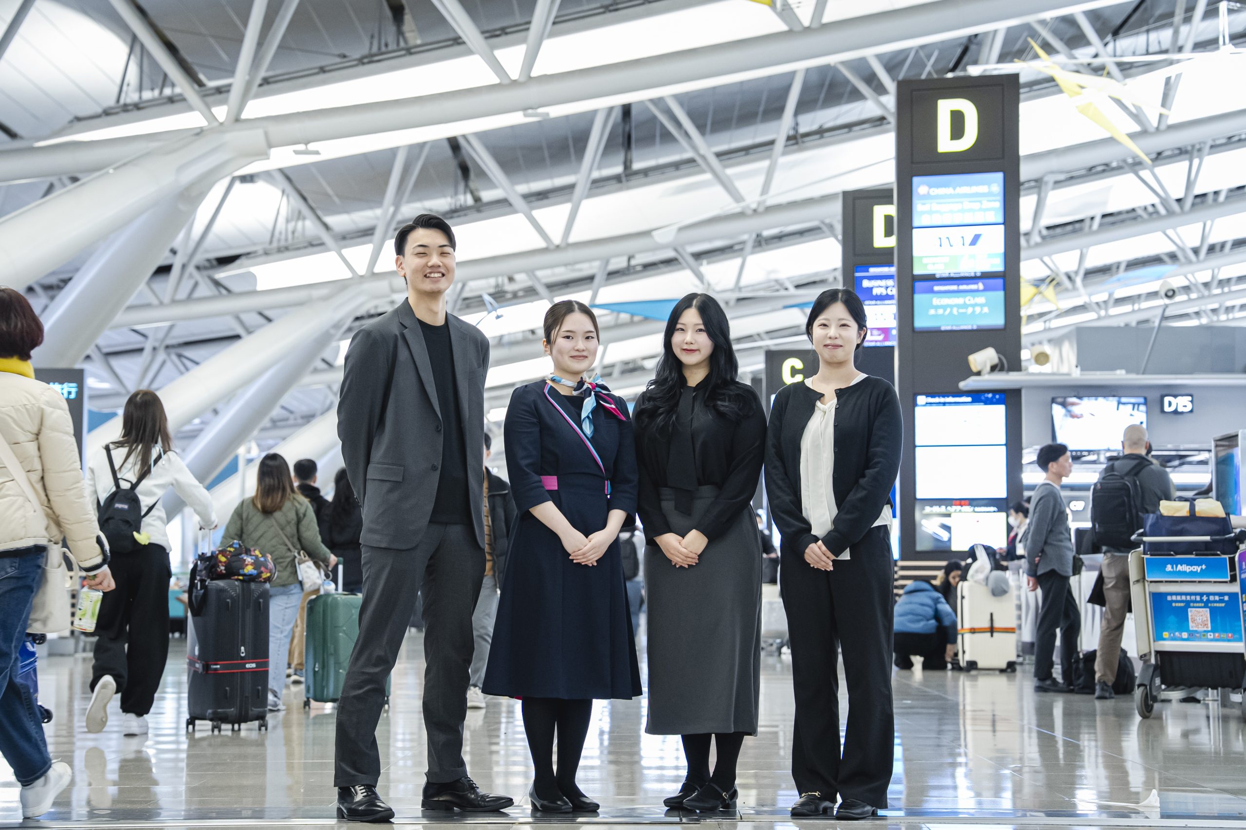 空港に並んで立つK.Yさん、F.Mさん、J.Kさん、T.Tさん／K.Y, F.M, J.K and T.T at the airport